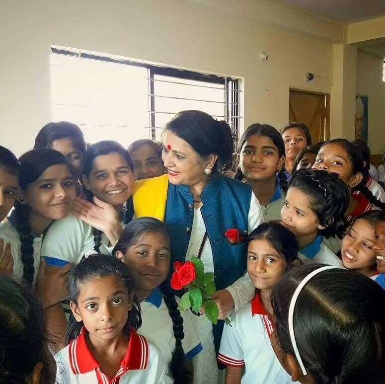 Shri Maa among schoolgirls holding roses.