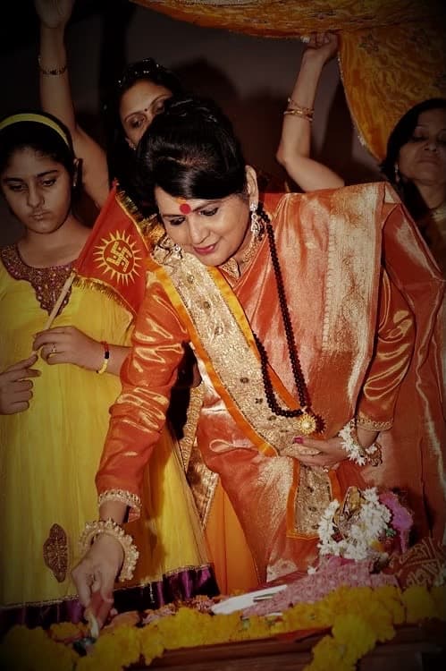 Shri Maa lighting a sacred lamp during an aarti.