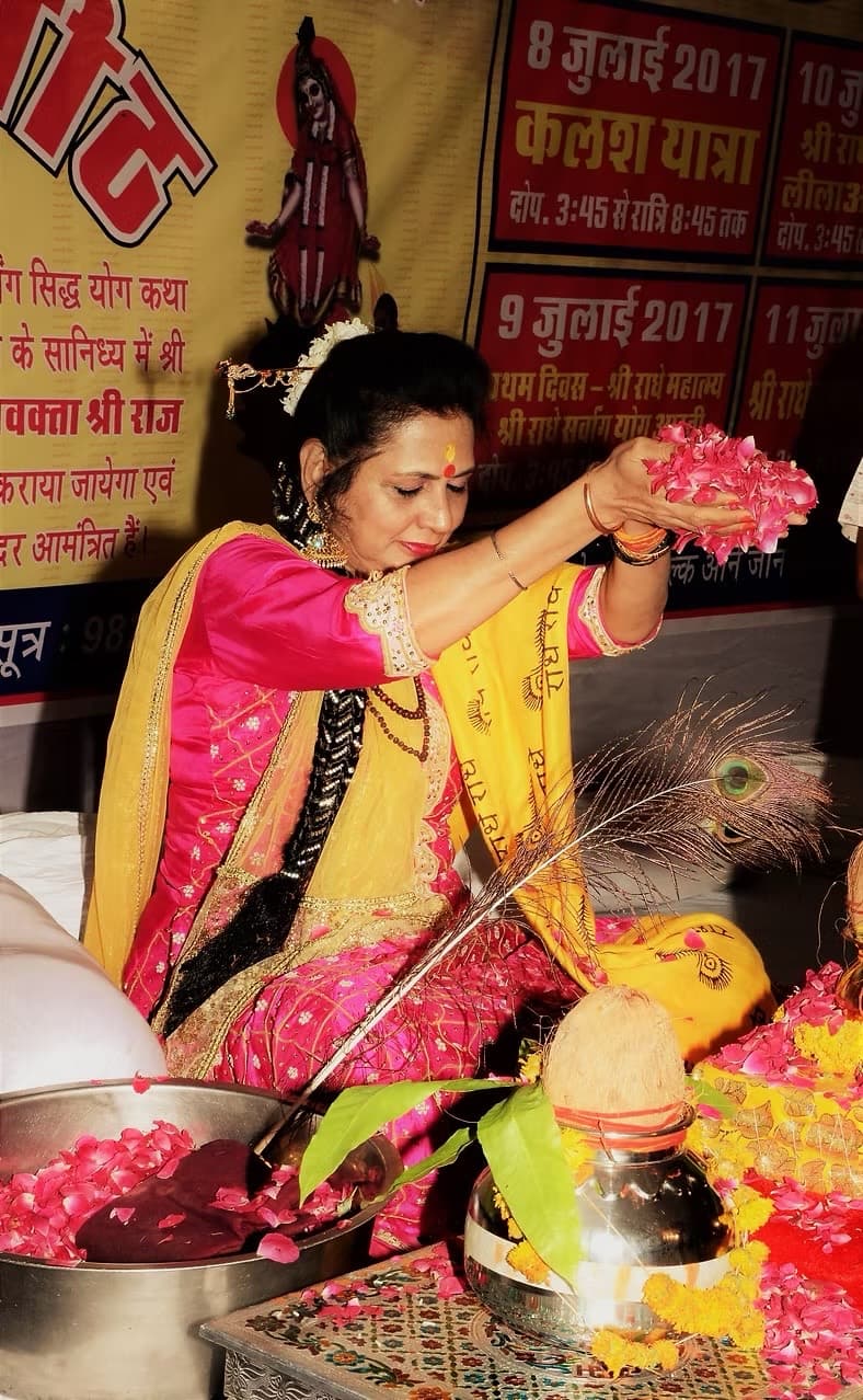 Shri Maa offering rose petals during a sacred puja.