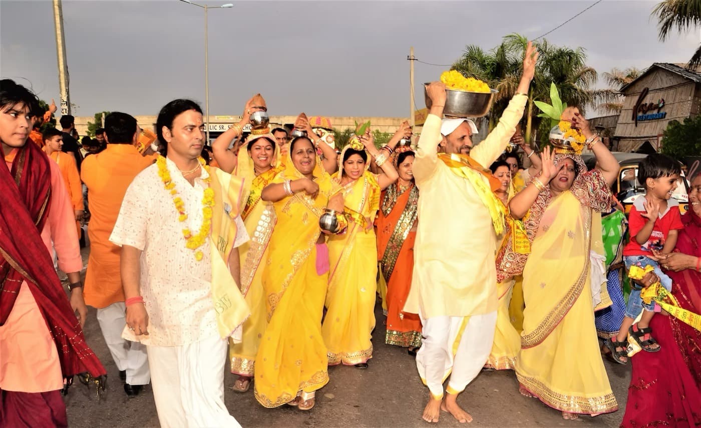 Devotees and volunteers in a kalash yatra through town.